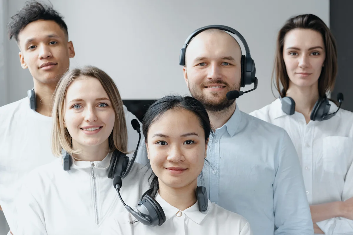 Five customer service professionals wearing headsets